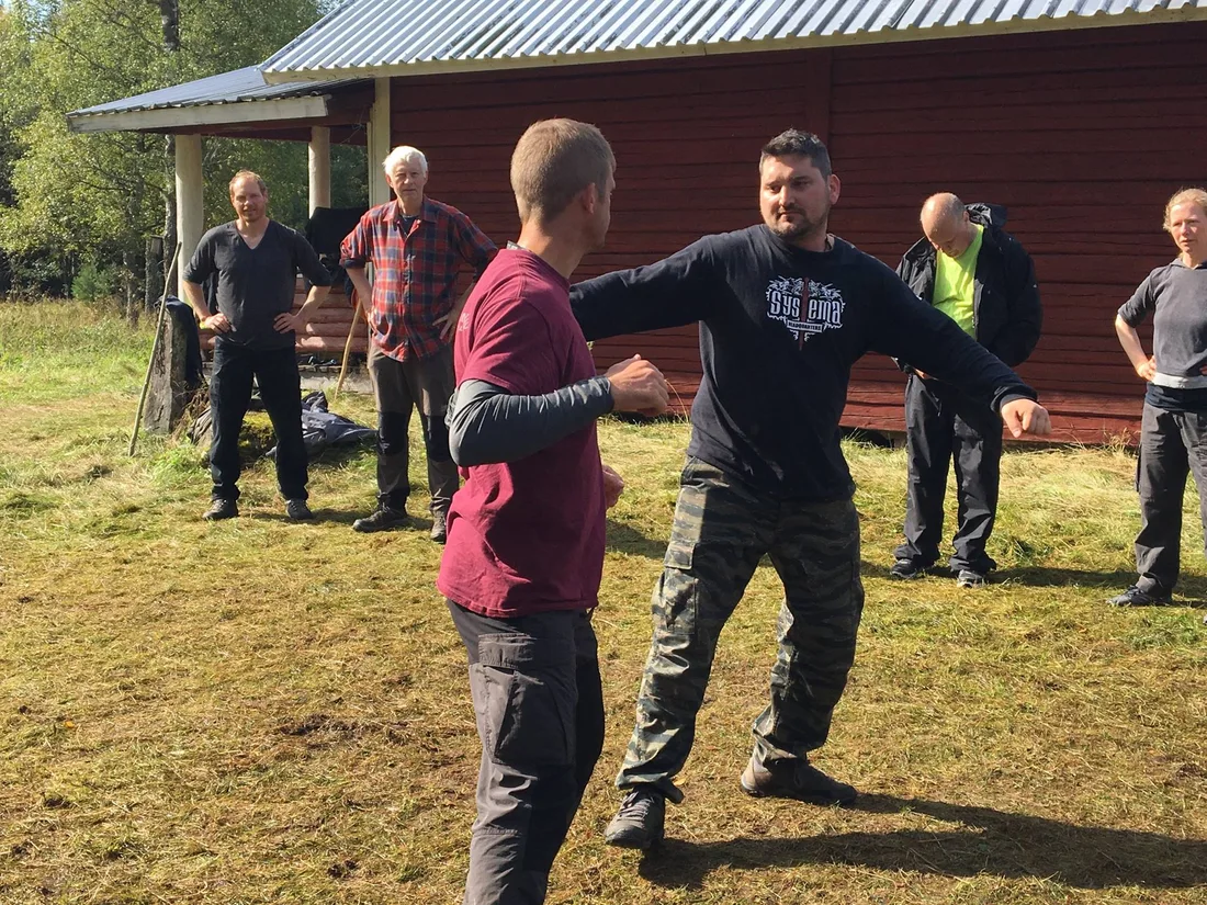 Systema partners practising movement outdoors at a training camp
